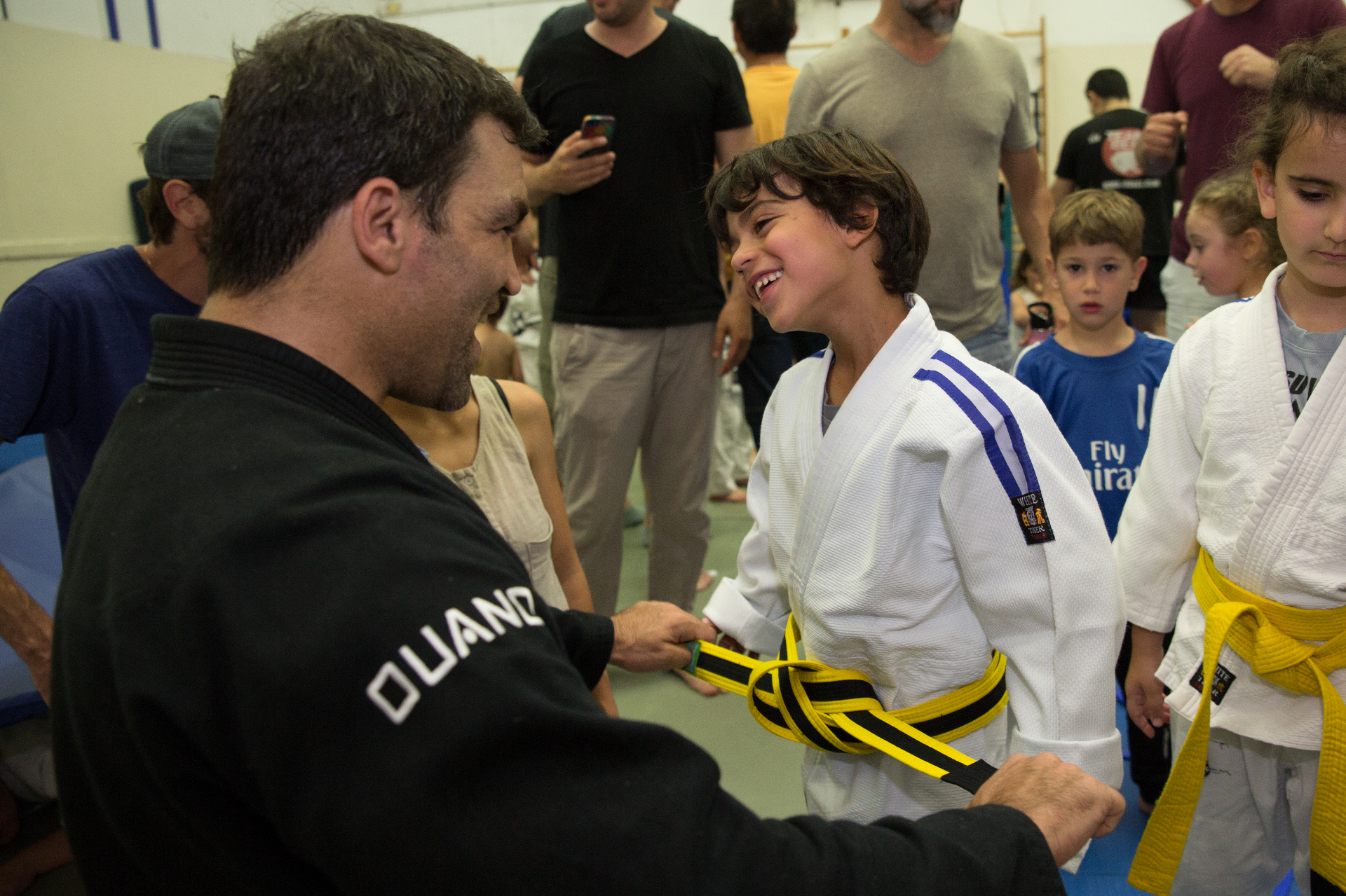 Coach awarding belt to smiling young student